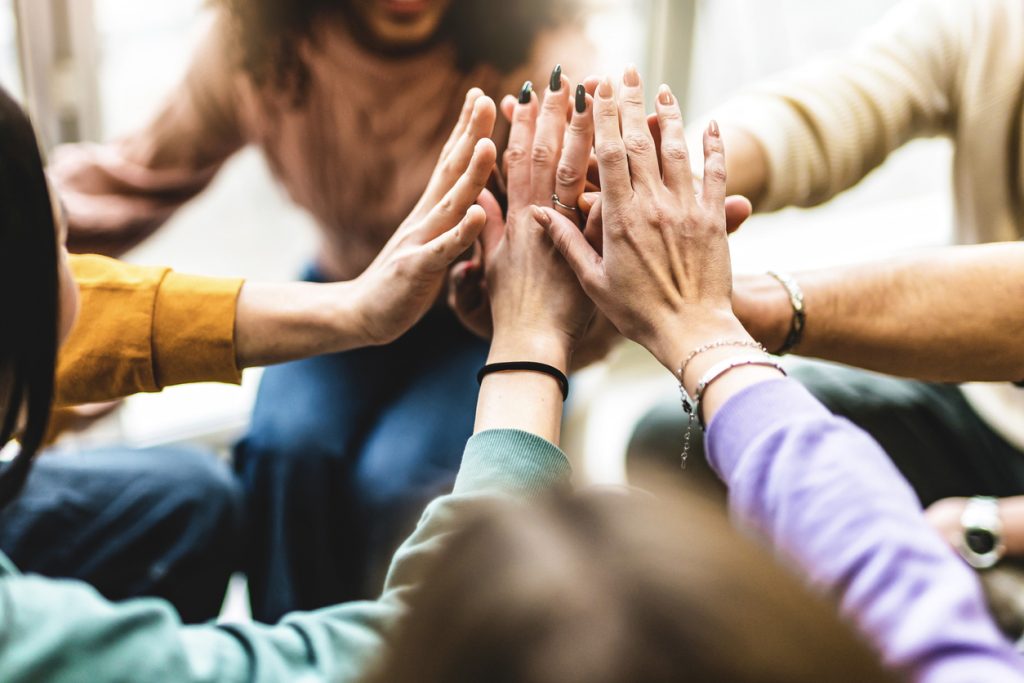 A group of people putting their hands together for team bonding